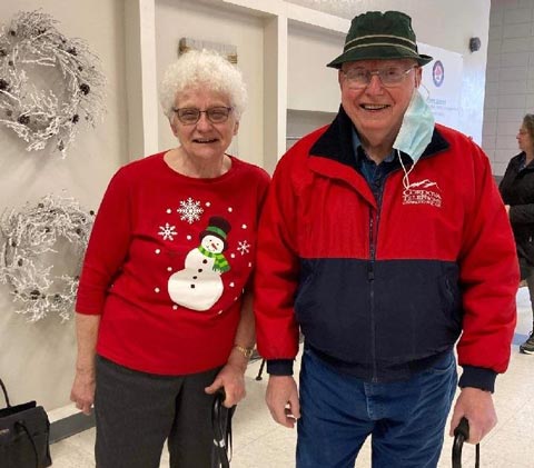 Older couple in red tops smiling for photo