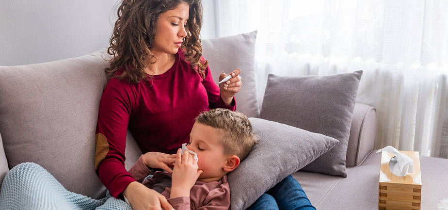 mother on couch with sick child