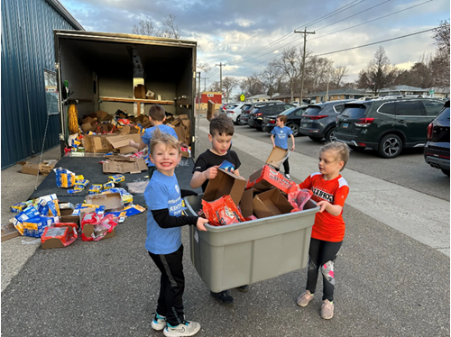 Group of kids loading empty boxes and wraps into a truck