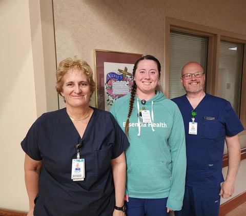 Ada Care Team standing shoulder to shoulder in hallway smiling for camera 